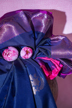Decorative fabric flower with pink and purple elements on a pink background