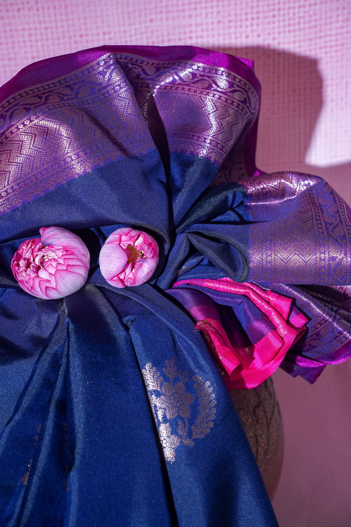 Decorative fabric flower with pink and purple elements on a pink background