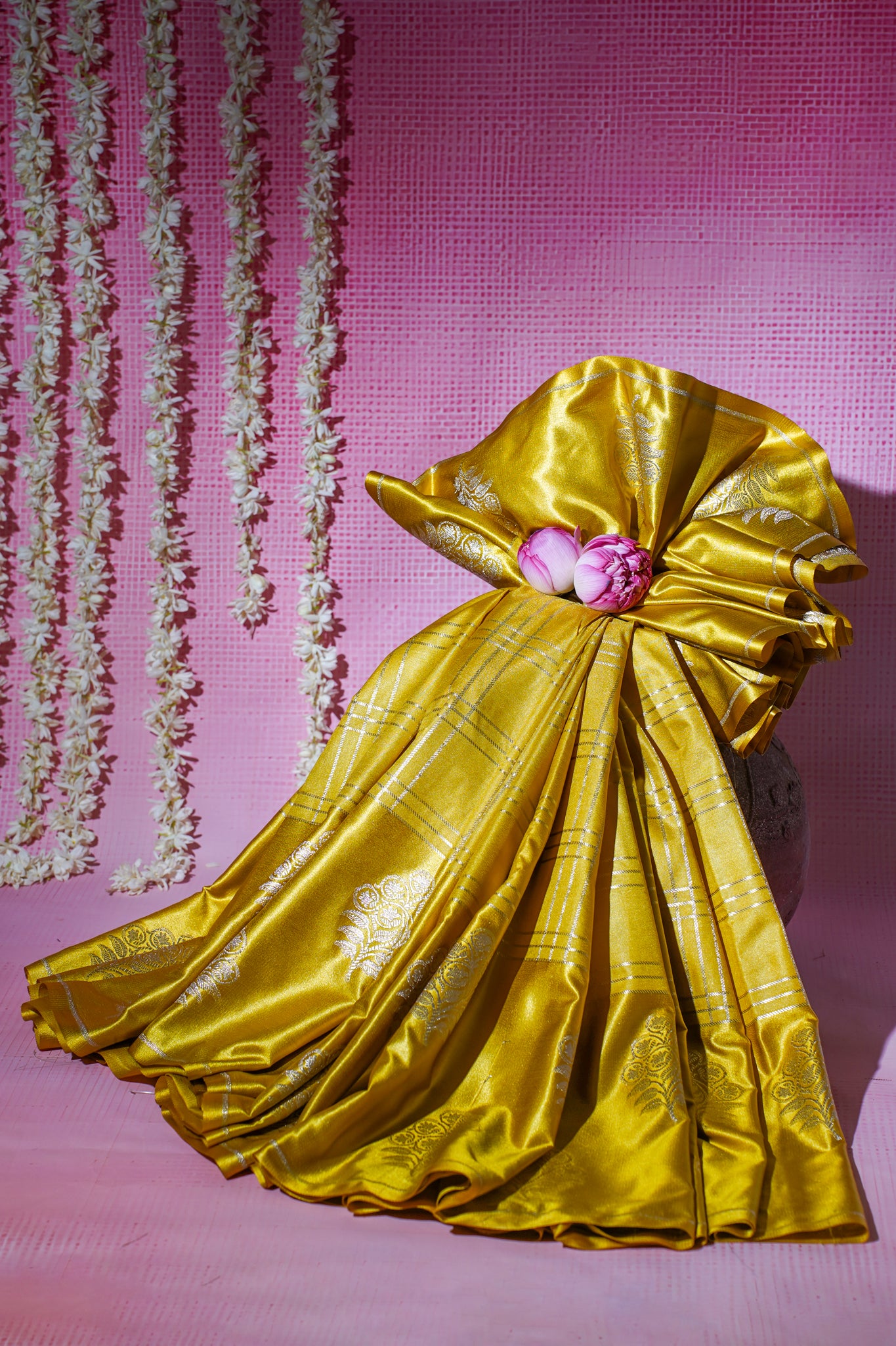 Gold fabric with a pink flower on a pink textured background