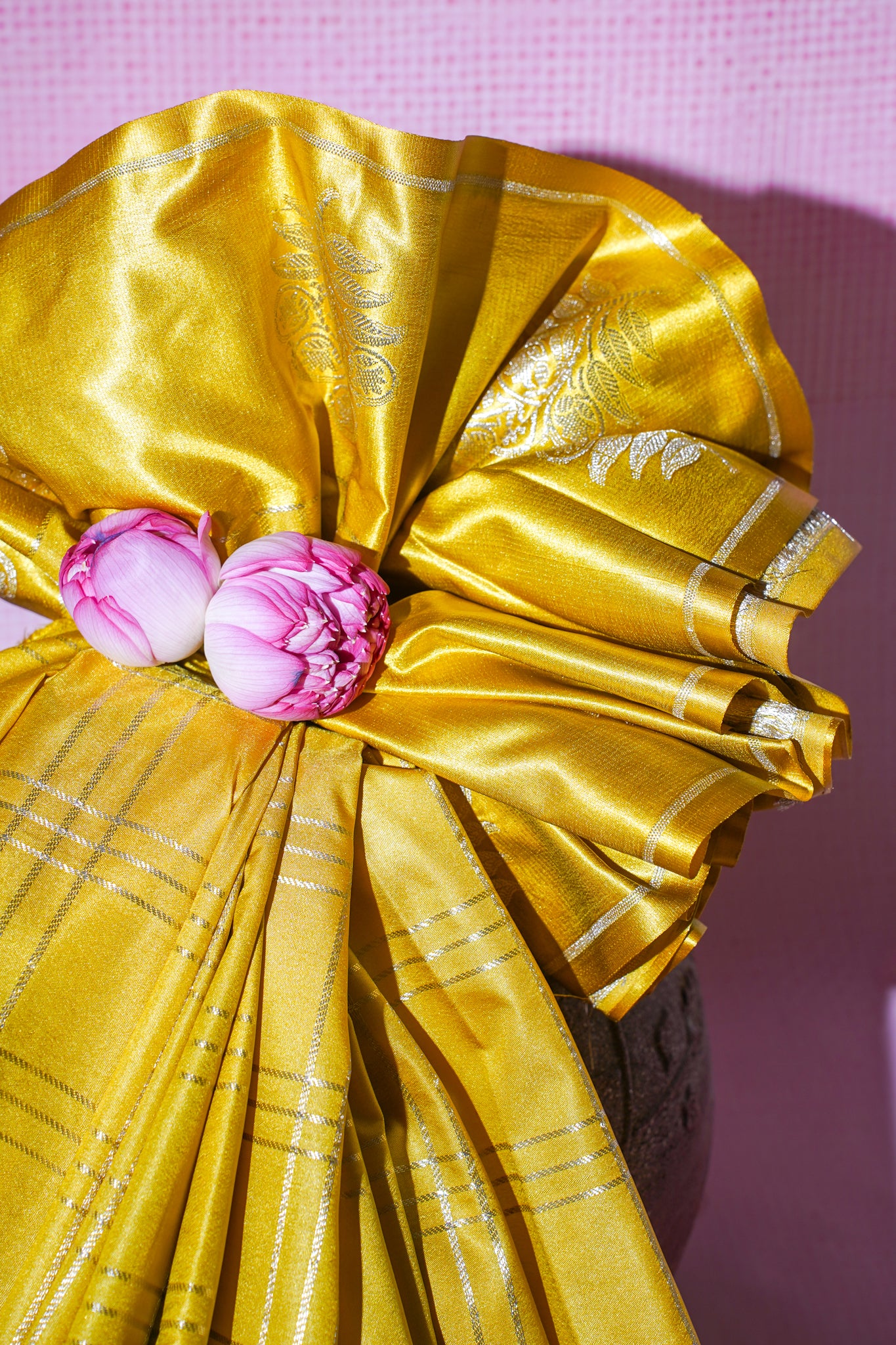 Gold saree with pink flowers on a pink background