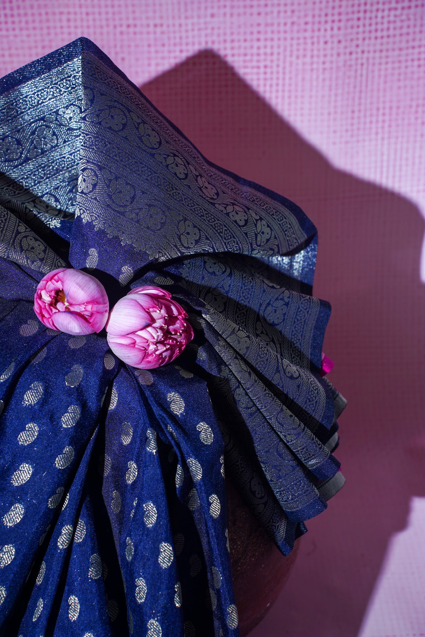 Blue fabric with pink floral decorations on a pink background