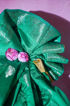 Green fabric with floral decorations on a pink background