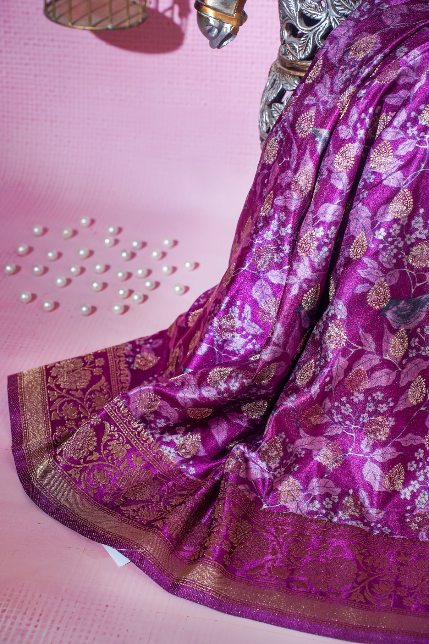 Purple saree with gold patterns on a pink background