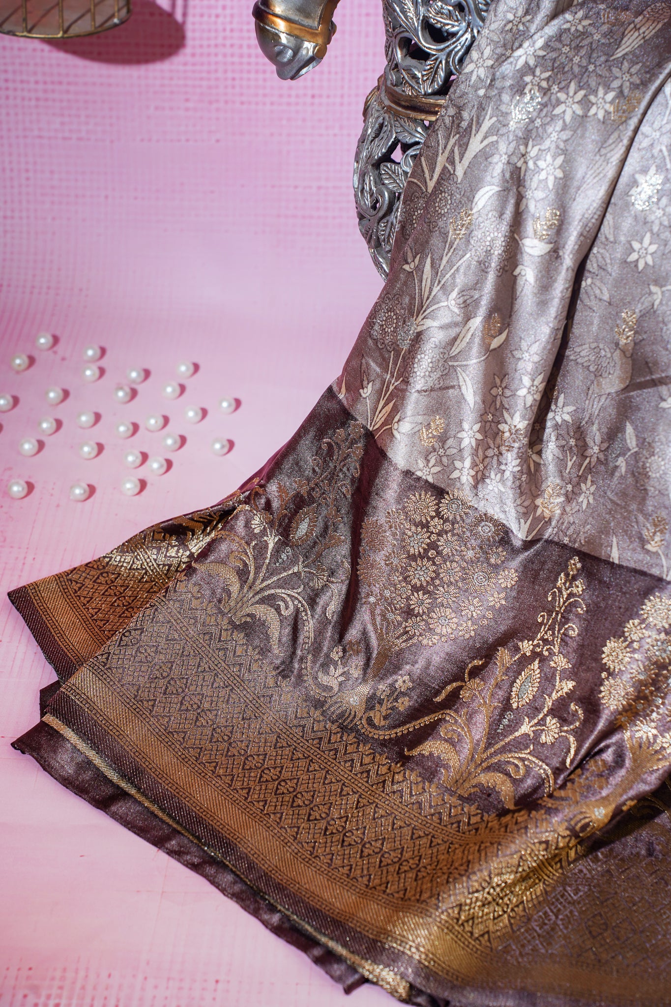 Silk saree with gold and silver patterns on a pink background