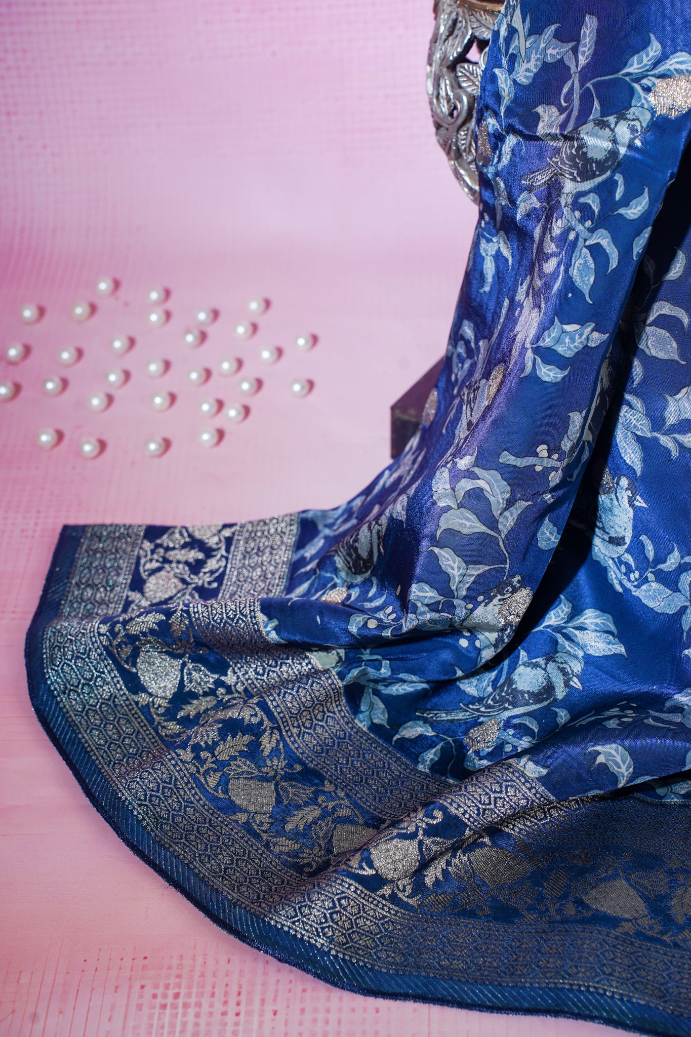 Blue saree with silver patterns on a pink background
