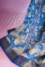 Blue saree with white floral and peacock design on a pink background